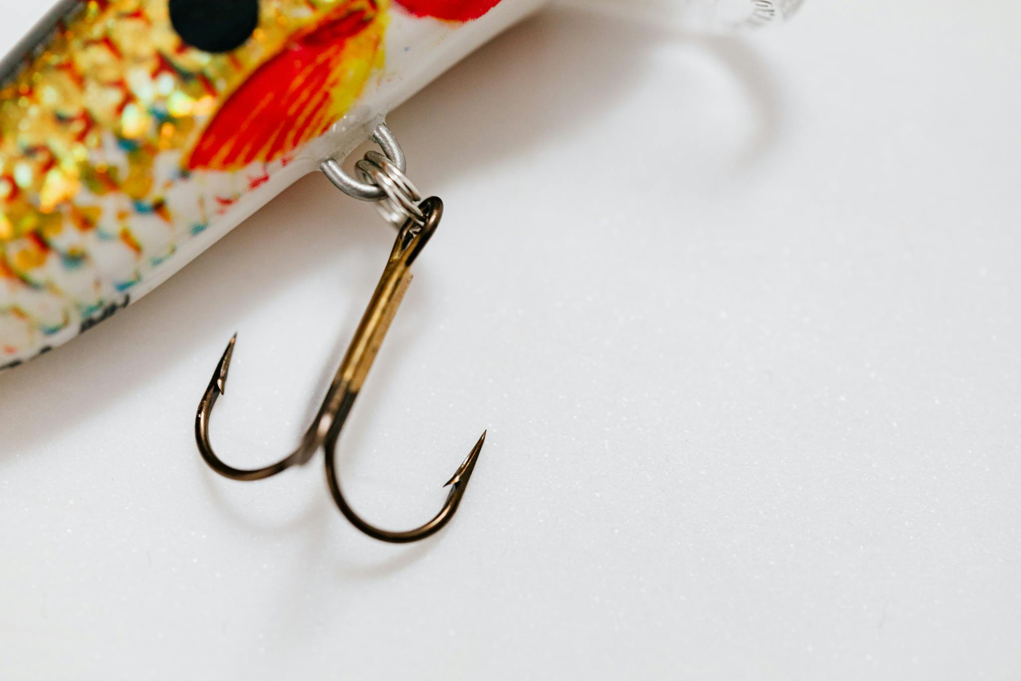 Detailed image of a vibrant fishing lure with sharp metal hooks on a clean background.